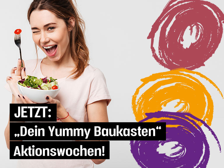 Gutgelauntes Mädchen isst Salat zu Yummy Baukasten Produkten