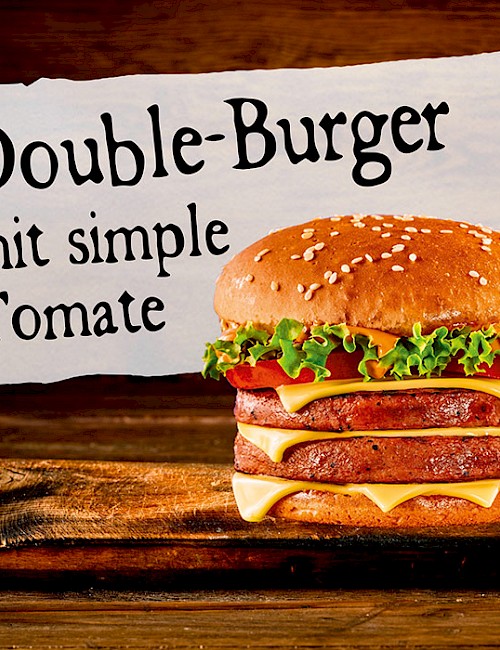 Double-Burger mit simple Tomate auf Brett angerichet