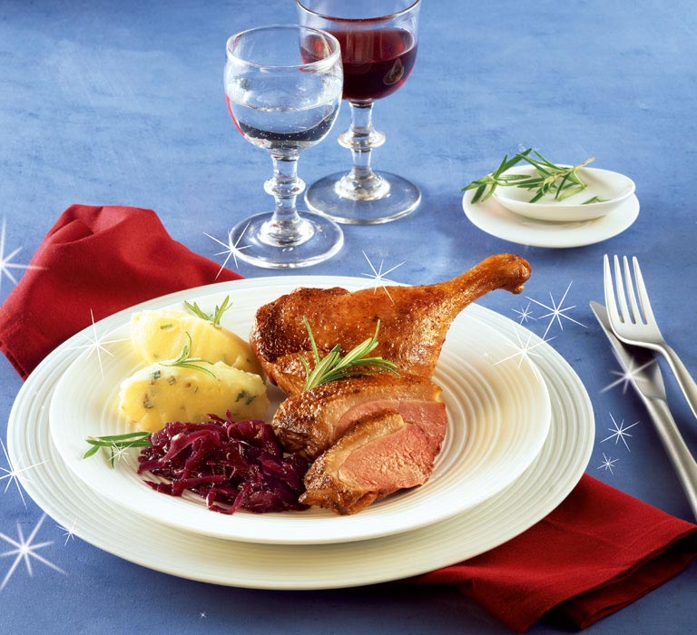 Ente mit Holunder-Rotkohl und Rosmarin-Kartoffelpüree auf einem weißem Teller serviert