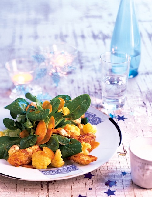 Feldsalat mit Gemüse und WIESENHOF Hähnchenschnitzel auf Tisch angerichtet